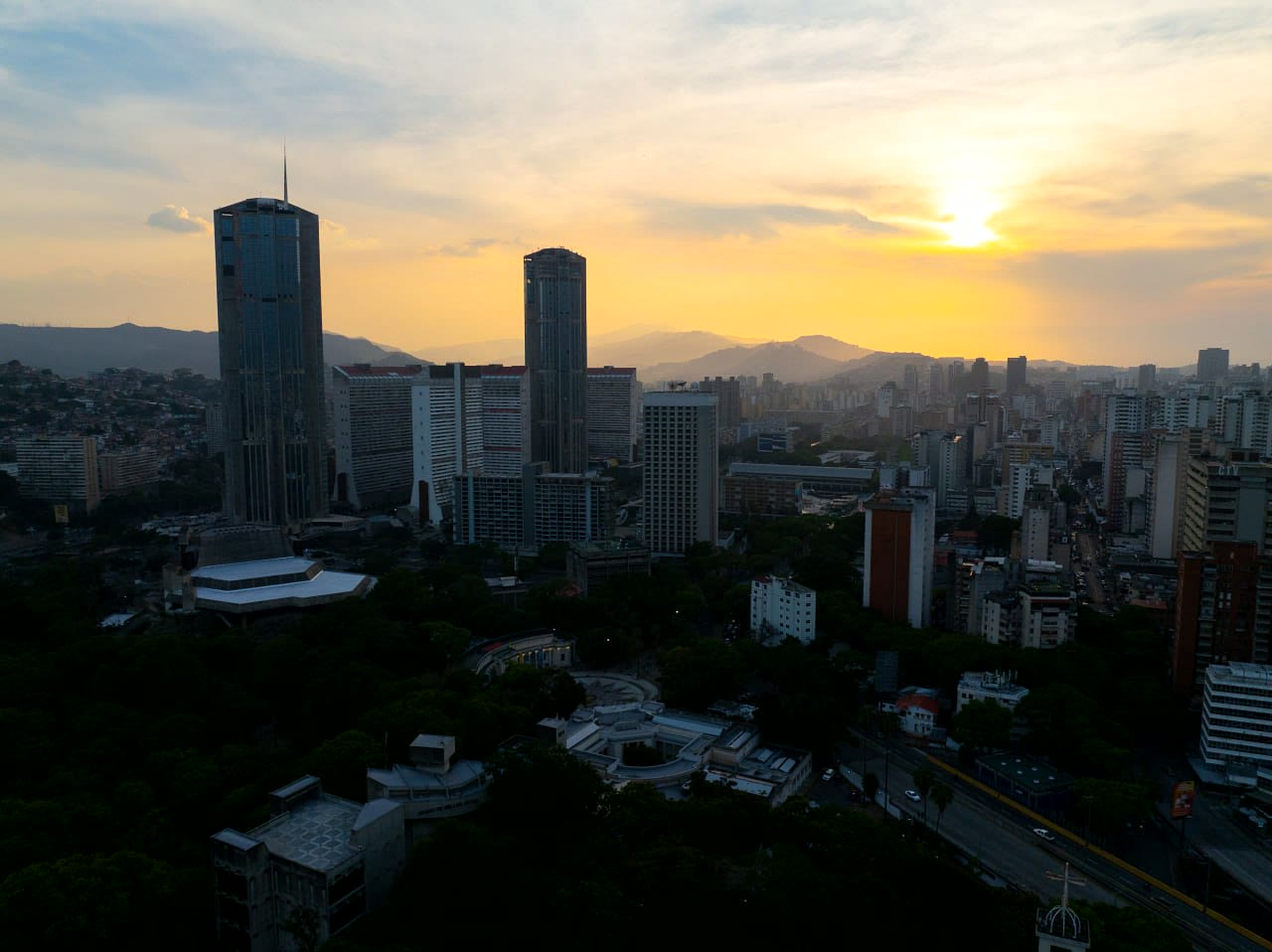 Panorámica aérea de una zona urbana y sus montañas al atardecer